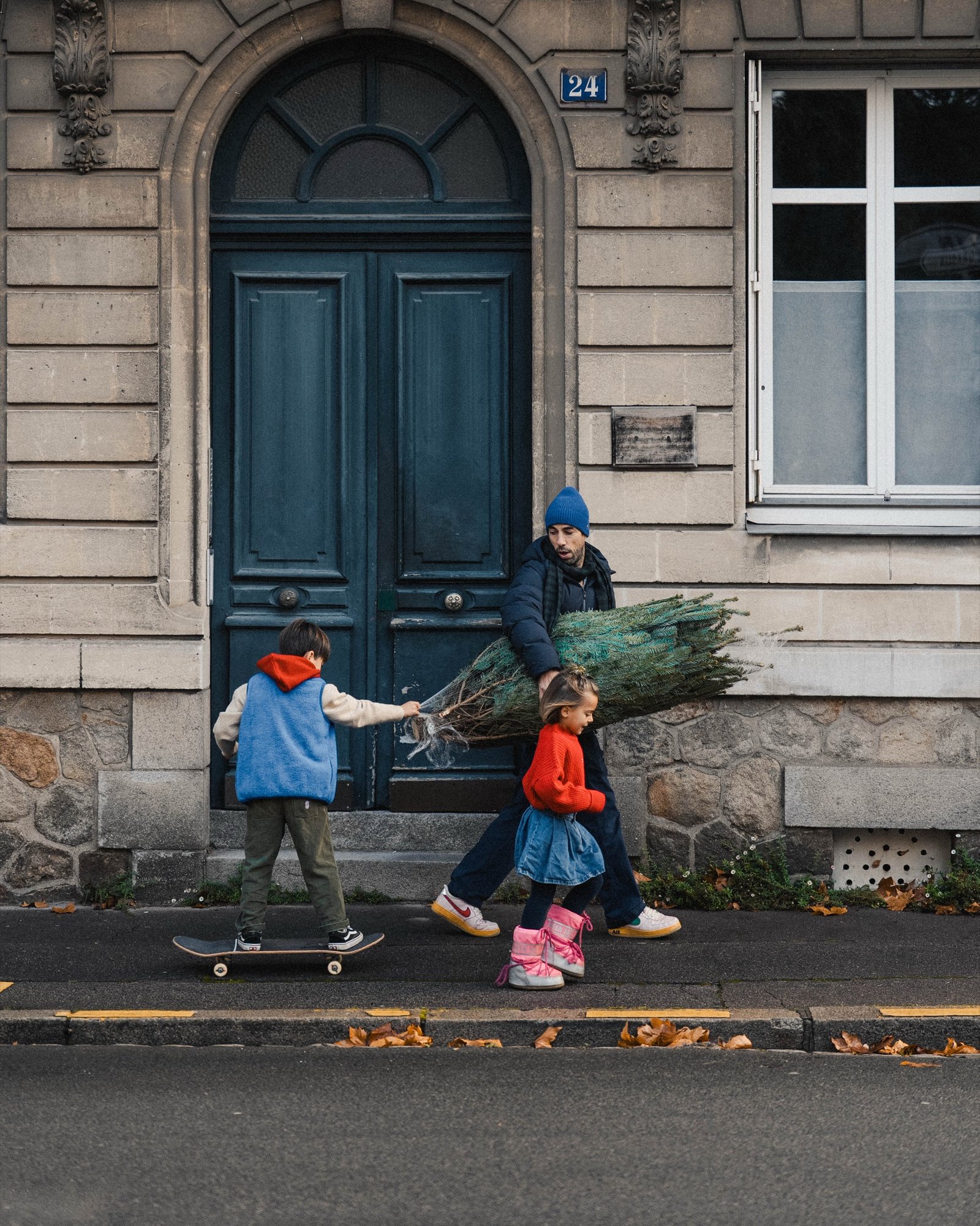 Smala — sapin sous le bras devant une porte nantaise