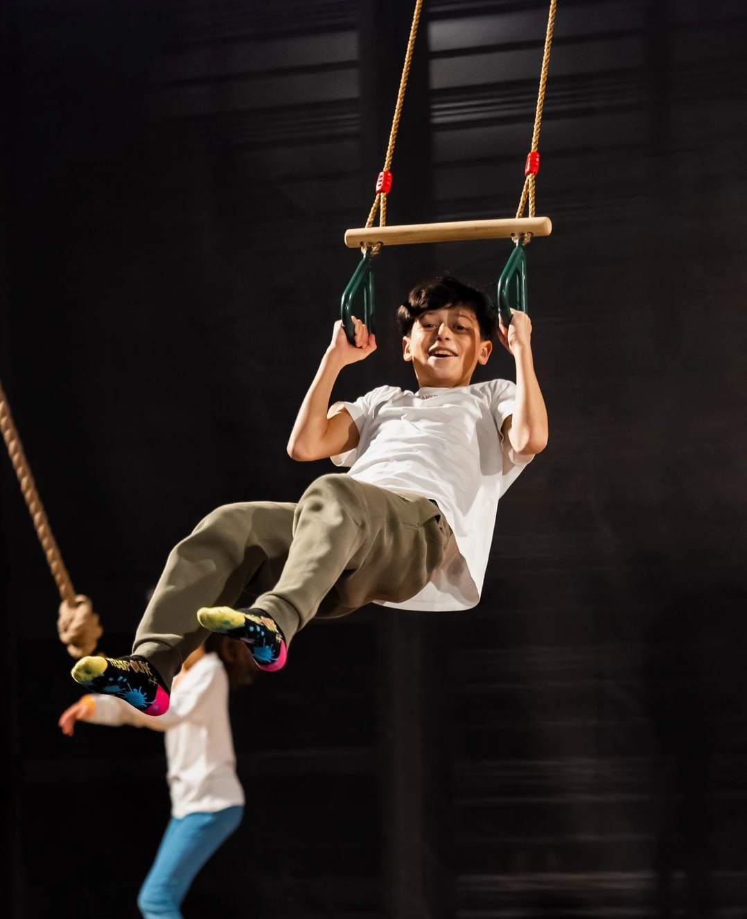 Trampoline 44 — enfant suspendu au trapèze